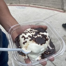 a hand holding a container of ice cream