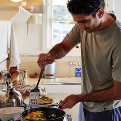 Mar Vista Farm + Cottages - A guest making breakfast in the fully equipped kitchen at Mar Vista.