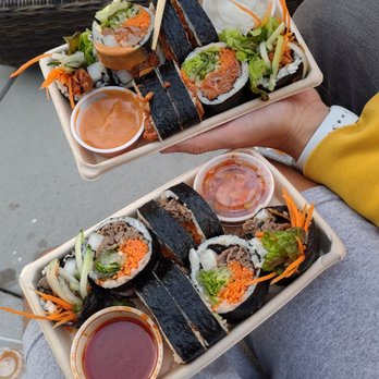 Kimbap Lab - a person holding chopsticks over a tray of food - Korean Near Me - Brooklyn, New York Kimbap Lab - a person holding chopsticks over a tray of food - Korean Near Me - Brooklyn, New York