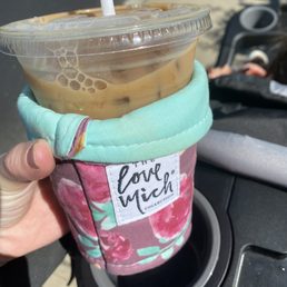 a hand holding a cup of iced coffee