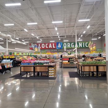 H-E-B - A grocery store interior featuring produce displays, bright lighting, and a large sign that says 'Local & Organic,' indicating a focus on fresh, local, and organic products. - Grocery Near Me - Austin, Texas