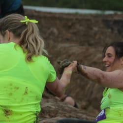 Freedom Martial Arts - Justine Freemen assisting a fellow Mudderella get over a tough obstacle. Women helping women to "own our strong!"