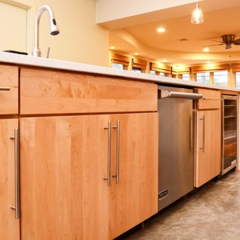 Bailey & Bear Construction - a kitchen with wood cabinets and stainless steel appliances - General Contractors Near Me