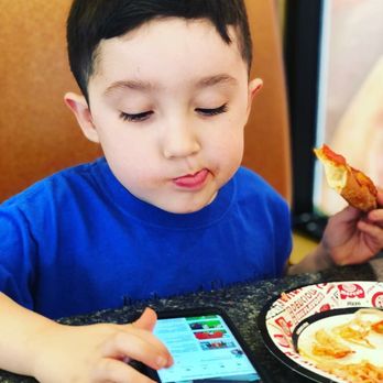 Mario's Pizza - a young boy eating a piece of pizza - Pizza Near Me - Pasadena, Texas Mario's Pizza - a young boy eating a piece of pizza - Pizza Near Me - Pasadena, Texas