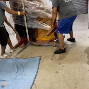 Expert Movers - Baby grand piano being moved with the legs attached, not on a piano board. - Movers Near Me - Chicago, Illinois