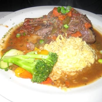 Max's Grill - Braised Lamb Shanks with onion and tomatoes in a veal stock, served with saffron rice - Seafood Near Me - Pacific Grove, California Max's Grill - Braised Lamb Shanks with onion and tomatoes in a veal stock, served with saffron rice - Seafood Near Me - Pacific Grove, California