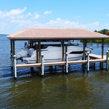 Land And Sea Marine - Custom covered boat lift with tile roof to match home, composite decking, and white piling caps. Dock Experts, Boathouse, Satellite Beach - General Contractors Near Me - Indialantic, Florida Land And Sea Marine - Custom covered boat lift with tile roof to match home, composite decking, and white piling caps. Dock Experts, Boathouse, Satellite Beach - General Contractors Near Me - Indialantic, Florida