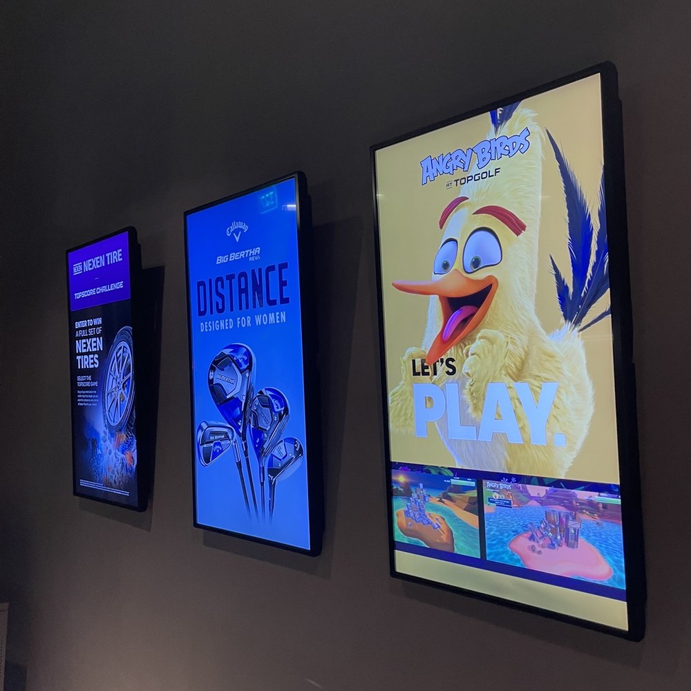 Topgolf - a row of movie posters on a wall - Golf Near Me - Charlotte, North Carolina Topgolf - a row of movie posters on a wall - Golf Near Me - Charlotte, North Carolina