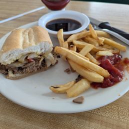 Philly sandwich and french fries. Au jus on the side.