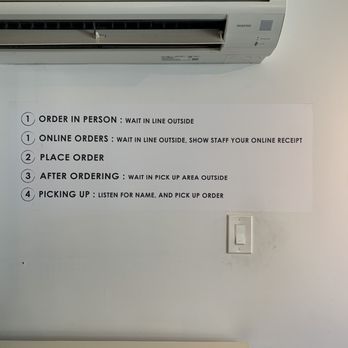 Cafe Cotton Bean - Order process - A wall-mounted sign detailing the order process at a business, with an air conditioner above and a light switch below. - Coffee & Tea Near Me - Brooklyn, New York