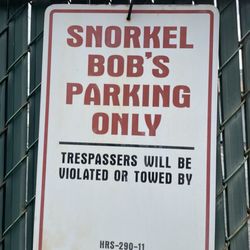 Snorkel Bob's Kapaa - A sign saying "SNORKEL BOB'S PARKING ONLY TRESSPASSERS WILL BE VIOLATED OR TOWED BY HRS-290-11
