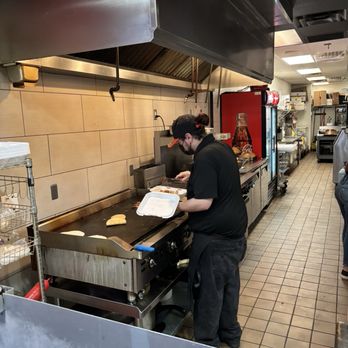 Nonno’s Taco Shop - This is one of the employees getting a takeout order ready to go. They have a huge grill. - Mexican Near Me - Phoenix, Arizona