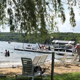 small beach with 15 people boat at the dock