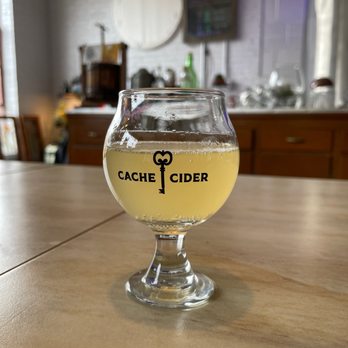 Cache Cider - a glass of cid on a table - Cideries Near Me - Milwaukee, Wisconsin Cache Cider - a glass of cid on a table - Cideries Near Me - Milwaukee, Wisconsin