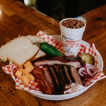 Johnny's Steaks & Bar-Be-Que - ows a plate of meat, bread, pickles, pickles, and a - Steakhouses Near Me - Salado, Texas