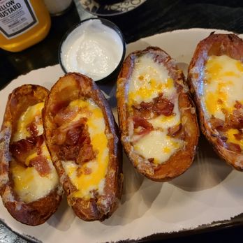 Taylor’s Bar & Table - Potato Skins app: crispy potato boats loaded with cheese and bacon served with a side of sour cream. - Burgers Near Me - Pendleton, Indiana