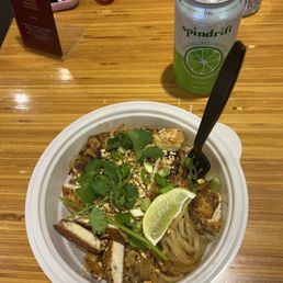 a bowl of noodles and a can of soda a bowl of noodles and a can of soda