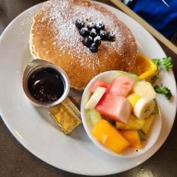 Blueberry pancakes with a side of fresh fruit