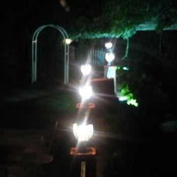 La Foret - The yard of La Foret @ night. On the left side of the brick pillar lamps are chairs &tables, on the right side is the creek. - French Near Me - San Jose, California