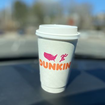 Dunkin' -  a cup of coffee sitting on the dashboard of a car - Donuts Near Me - Quincy, Massachusetts