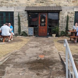 a group of people sitting outside of a building a group of people sitting outside of a building