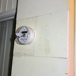 My electrical meter with a cover and caulk to seal entry points