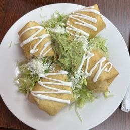 Chicken and steak chimichangas topped with guacamole. Chicken and steak chimichangas topped with guacamole.