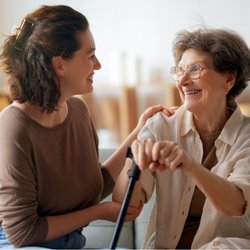 Family Choice Home Care - Caregiver warmly assisting an older woman with mobility, highlighting companionship, personal support, and maintaining indepe...