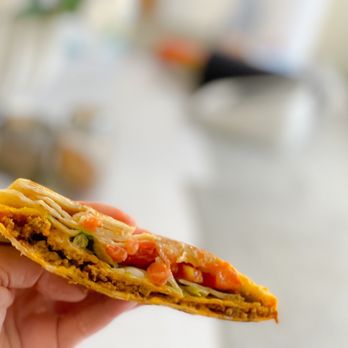 Taco Bell - a hand holding a piece of food - Fast Food Near Me - Hoover, Alabama