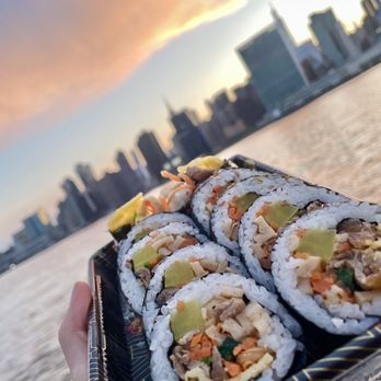 Lim's Kitchen - a person holding a tray of sushi - Chicken Wings Near Me - Astoria, New York
