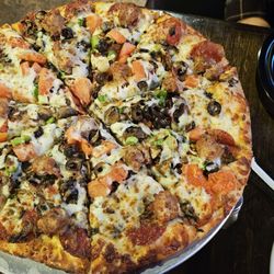 Slice of Italy - Pizza with Peperoni Olives Sausage Bacon and Fresh Tomatoes