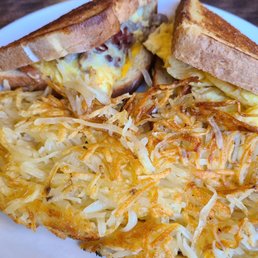 a plate of food with a sandwich and hash browns a plate of food with a sandwich and hash browns