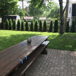 a wooden picnic table in a backyard a wooden picnic table in a backyard