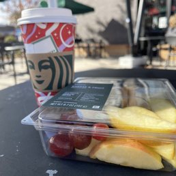 a container of fruit and a cup of coffee a container of fruit and a cup of coffee