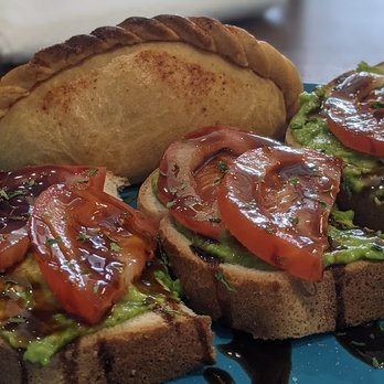 Blue Bean - Avocado toast with tomatoes, basil and balsamic glaze, empanada in the background. - Coffee & Tea Near Me - Ankeny, Iowa