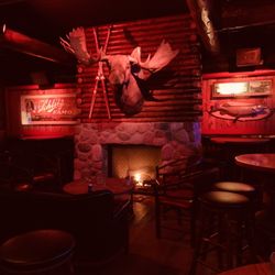Camp Bar Third Ward - Right side of the bar area after walking in the front door, with the fireplace the main highlight. TVs along the wall to the right as well.
