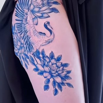 Nieu Studio - Tattoo on the right thigh, all blue and resembling porcelain, featuring a lotus flower on top and bottom with a crane in flight between. - Tattoo Near Me - Seattle, Washington Nieu Studio - Tattoo on the right thigh, all blue and resembling porcelain, featuring a lotus flower on top and bottom with a crane in flight between. - Tattoo Near Me - Seattle, Washington