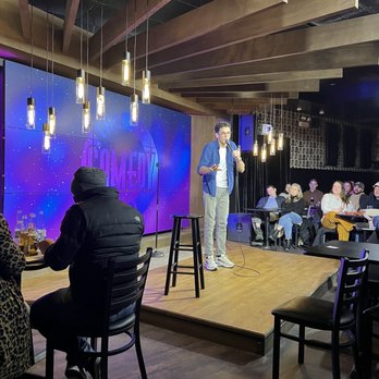 The Comedy Bar - a man standing on stage giving a presentation - Comedy Clubs Near Me - Chicago, Illinois The Comedy Bar - a man standing on stage giving a presentation - Comedy Clubs Near Me - Chicago, Illinois