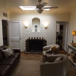 The Wilshire House Phoenix - The Sun Room with original stained concrete floor and molding, skylight, and queen-sized leather sleeping couch.