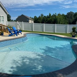 Wise Pool & Spa Service - Freeform inground swimming pool with raised wall and water feature, and Wet Edge Signature Matrix Coastal Blue interior finish.