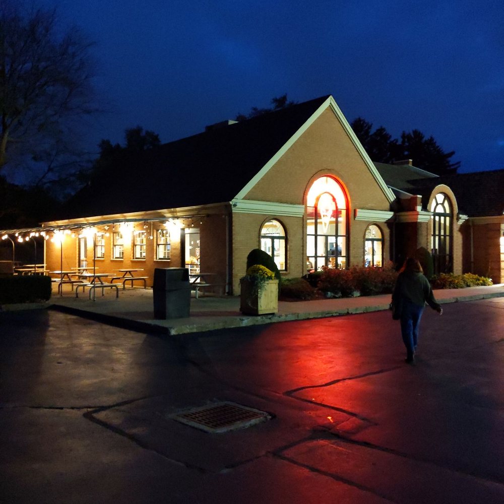 a person walking in front of a building at night