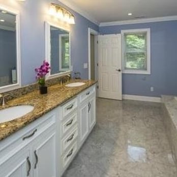 Exceptional Home Improvements - a large bathroom with marble countertops - Roofing Near Me