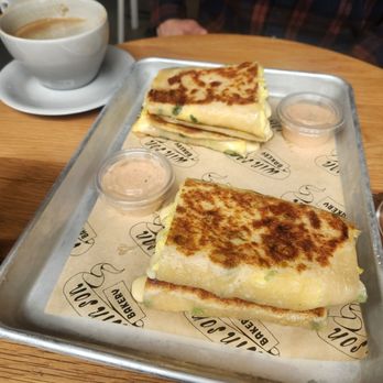 Win Son Bakery - Egg and cheese scallion pancakes are served like sandwiches with a chipotle mayo side. Latte in background. - Bakeries Near Me - New York, New York