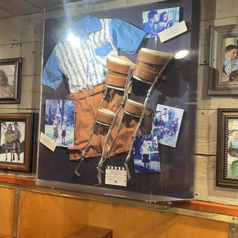 Bubba Gump Shrimp - Inside are various Forrest Gump movie props in frames. This is young Forrest's clothes and leg brace with photos. - Seafood Near Me - Long Beach, California