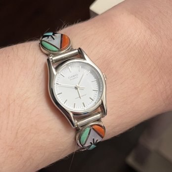 Timeland - A top view of a thin silver watch with colorful stonework accents worn on a wrist. - Watch Repair Near Me - Los Angeles, California Timeland - A top view of a thin silver watch with colorful stonework accents worn on a wrist. - Watch Repair Near Me - Los Angeles, California