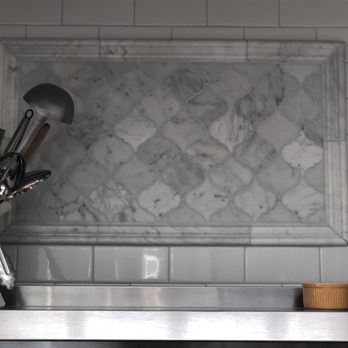 Mike Reed Tile - Carrara marble trim and arabesque tiles create the framed design detail above the range - Tiling Near Me - Tarzana, California Mike Reed Tile - Carrara marble trim and arabesque tiles create the framed design detail above the range - Tiling Near Me - Tarzana, California