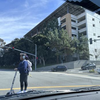 In-N-Out Burger - A student on her electric scooter crossing the street, most likely to go eat at In and Out, LOL - Burgers Near Me - Irvine, California In-N-Out Burger - A student on her electric scooter crossing the street, most likely to go eat at In and Out, LOL - Burgers Near Me - Irvine, California