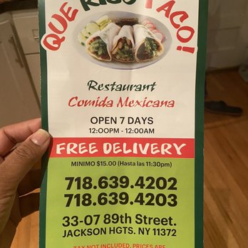 Que Rico Taco! - a person holding a sign - Mexican Near Me - Jackson Heights, New York