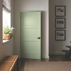 TW Perry - A cozy, modern hallway with a soft green, three-panel interior door slightly ajar. The space includes a woven bench, a window...
