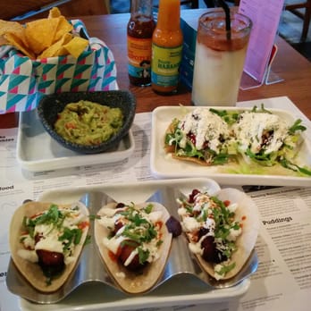 Wahaca - Plantain tacos in front, black bean tostadas behind to the right, guac and chips to the left and horchata in the glass. - Mexican Near Me - London, XGL